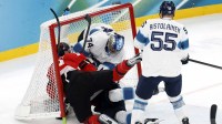 Sam Bennett of Canada collides with Juuse Saros of Finland, resulting in a penalty for goaltender interference in a men's ice hockey semifinal during the Milano Cortina 2026 Olympic Winter Games at Milano Santagiulia Ice Hockey Arena.