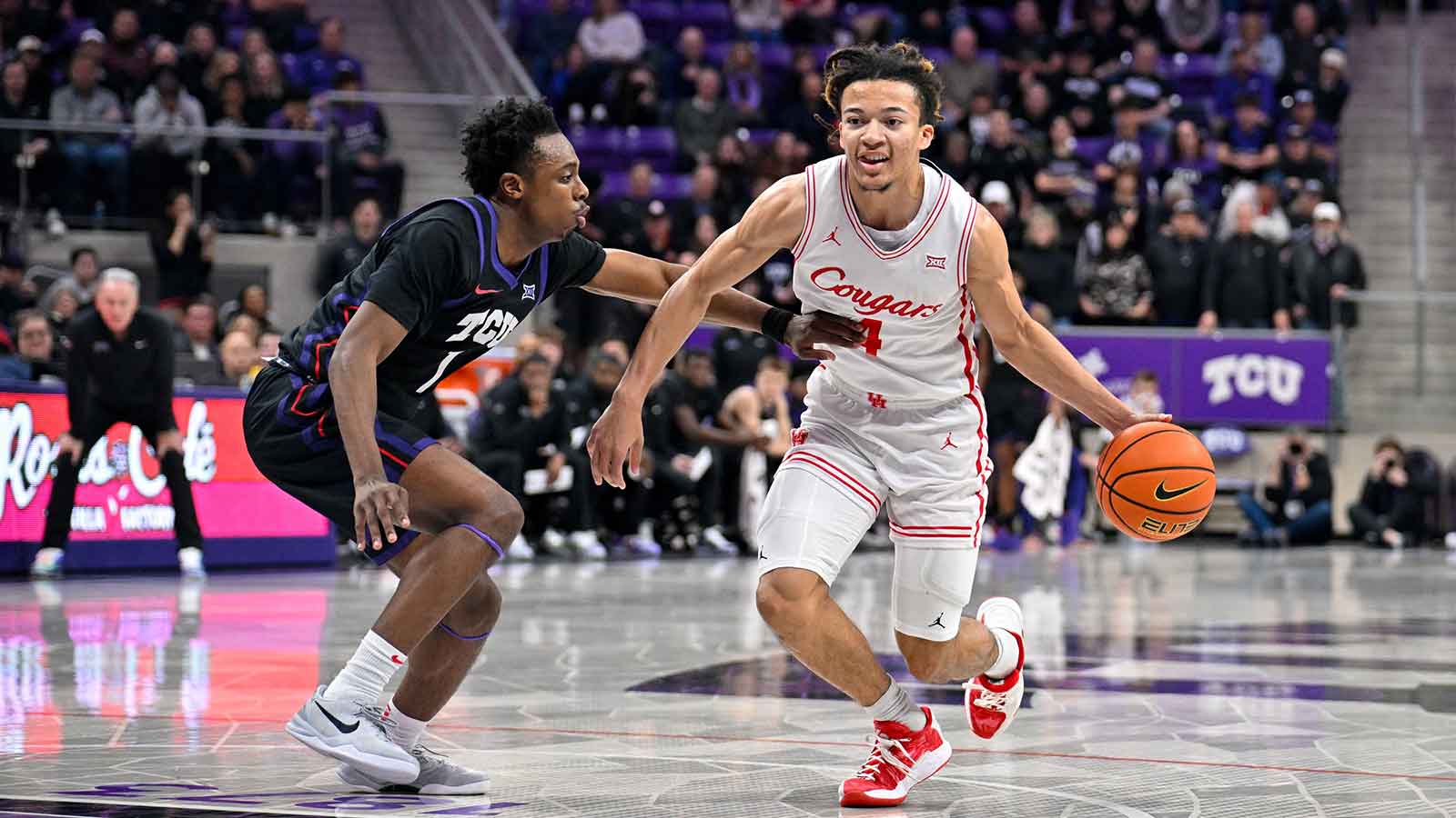 Houston Cougars guard Kingston Flemings (4) brings the ball up court past TCU Horned Frogs guard Jayden Pierre (1) during the game at Ed and Rae Schollmaier Arena.