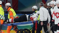 Kevin Fiala of Switzerland is taken off the ice by medical staff on a stretcher after sustaining an injury against Canada in men's ice hockey group A play during the Milano Cortina 2026 Olympic Winter Games at Milano Santagiulia Ice Hockey Arena.