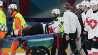 Kevin Fiala of Switzerland is taken off the ice by medical staff on a stretcher after sustaining an injury against Canada in men's ice hockey group A play during the Milano Cortina 2026 Olympic Winter Games at Milano Santagiulia Ice Hockey Arena.