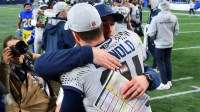 Seattle Seahawks quarterback Sam Darnold (14) hugs offensive coordinator Klint Kubiak after defeating the Los Angeles Rams in overtime at Lumen Field.