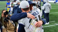 Seattle Seahawks quarterback Sam Darnold (14) hugs offensive coordinator Klint Kubiak after defeating the Los Angeles Rams in overtime at Lumen Field.