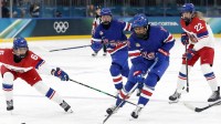 Laila Edwards (10) of Team United States battles for the puck with Linda Vocetkova (6) of Team Czechia in women's ice hockey Group A play during the Milano Cortina 2026 Olympic Winter Games at Milano Rho Ice Hockey Arena.