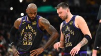 Los Angeles Lakers forward/guard Luka Doncic (77) talks with Los Angeles Lakers forward LeBron James (23) against the Washington Wizards during the second half at Capital One Arena.