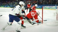 Leonardo Genoni of Switzerland in action with Alexandre Texier of France during a Group A men's ice hockey game during the Milano Cortina 2026 Olympic Winter Games at Milano Santagiulia Ice Hockey Arena