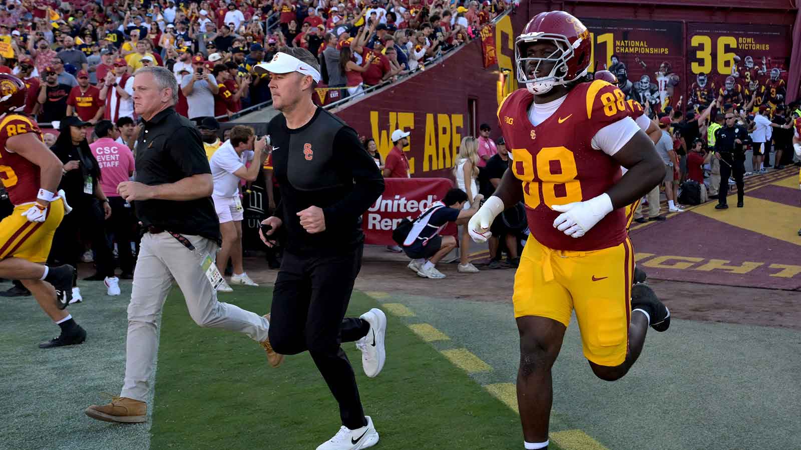 USC Trojans head coach Lincoln Riley, center, runs on to the field for the game against the Michigan Wolverines at United Airlines Field at the Los Angeles Memorial Coliseum.