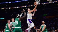 Los Angeles Lakers guard Luka Doncic (77) moves to the basket agianst Boston Celtics center Neemias Queta (88) and guard Derrick White (9) during the second half at Crypto.com Arena.