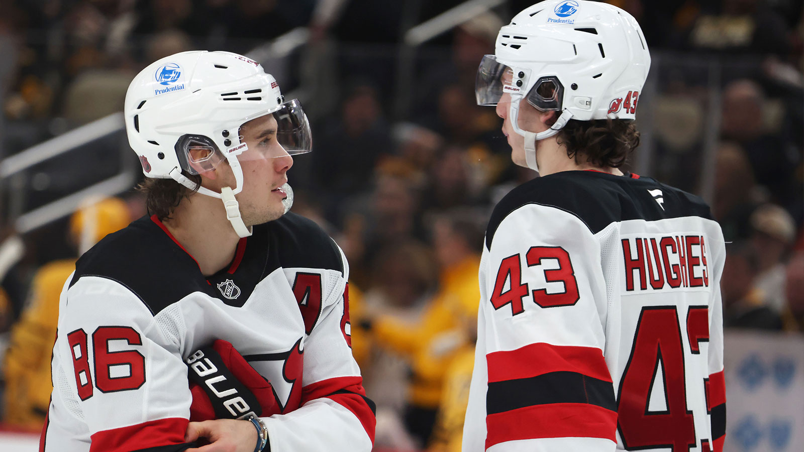 New Jersey Devils center Jack Hughes (86) talks with his brother defenseman Luke Hughes (43) before the start of the third period against the Pittsburgh Penguins at PPG Paints Arena.