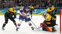 Matthew Tkachuk of United States in action with Maximilian Franzreb of Germany in men's ice hockey group C play during the Milano Cortina 2026 Olympic Winter Games at Milano Santagiulia Ice Hockey Arena.