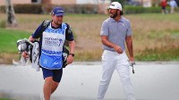 Max Homa (right) walks up to the eighth green with his caddie during the first round of the Cognizant Classic golf tournament.