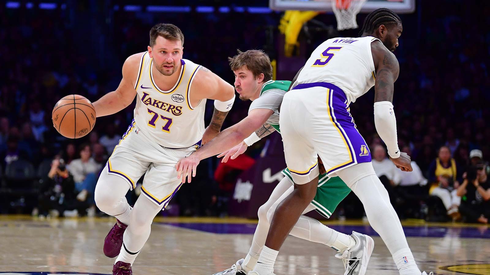 Los Angeles Lakers guard Luka Doncic (77) moves the ball as center Deandre Ayton (5) provides coverage against Boston Celtics guard Baylor Scheierman (55) during the second half at Crypto.com Arena.
