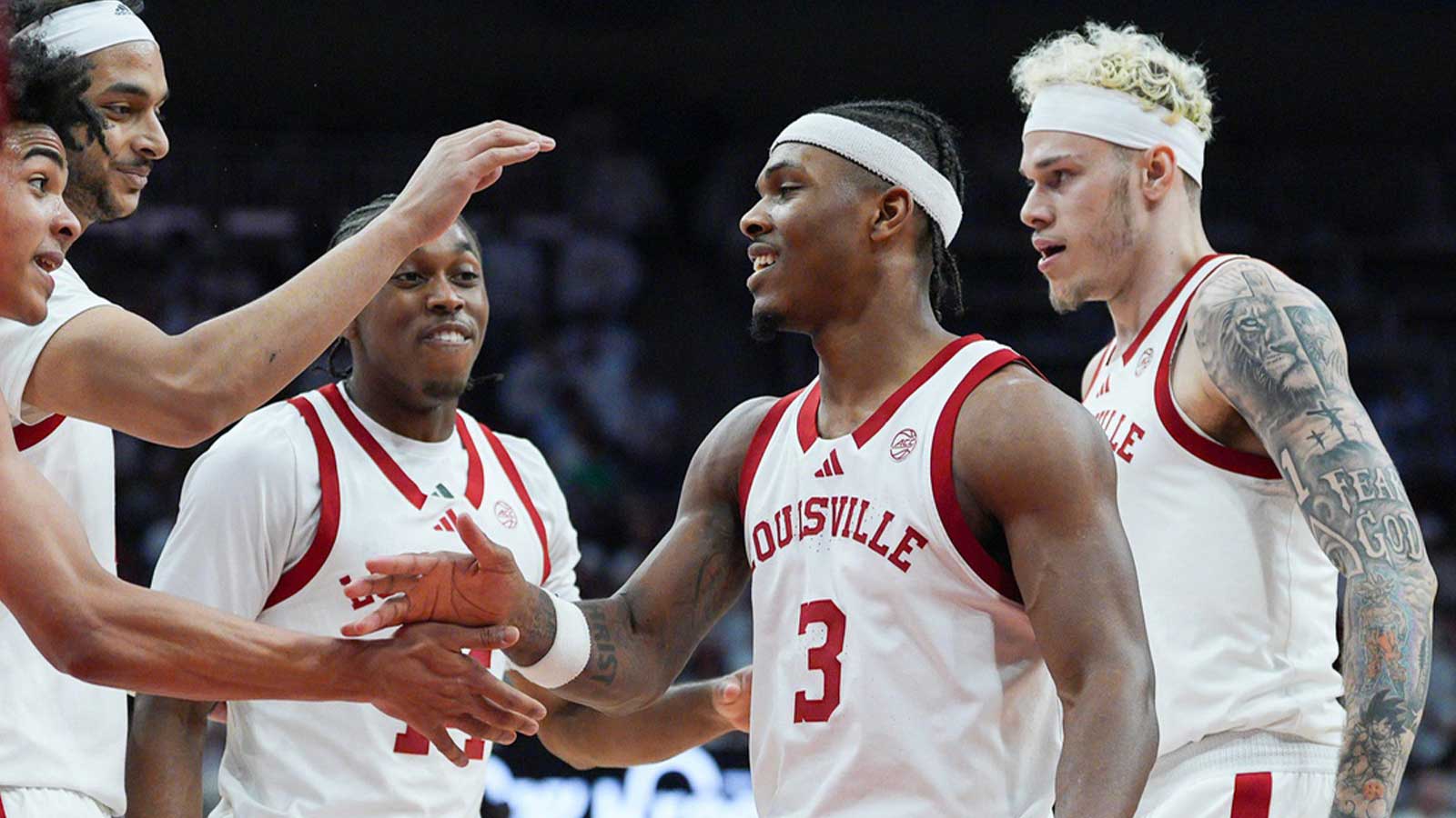 Louisville Cardinals guard Mikel Brown Jr. (0), left, celebrates with Louisville Cardinals guard Ryan Conwell (3) as Louisville Cardinals guard Adrian Wooley (14) and Louisville Cardinals forward Kasean Pryor (7) look on in the first half against NC State at the KFC Yum! Center in downtown Louisville February 9, 2026.