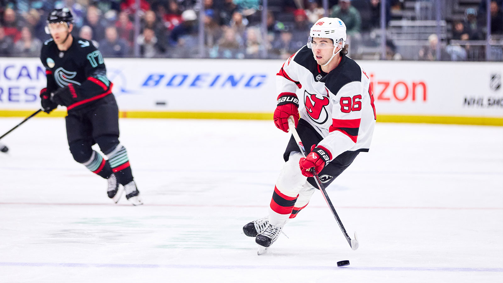 New Jersey Devils center Jack Hughes (86) skates with the puck and looks to pass during the second period against the Seattle Kraken at Climate Pledge Arena.