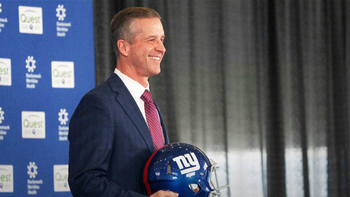 New Giants Head Coach John Harbaugh holds up a New York Giants helmet during a press conference welcoming Harbaugh at the Quest Diagnostics Training Center in East Rutherford on Tuesday, Jan. 20, 2025.