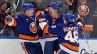 New York Islanders center Bo Horvat (14) celebrates his game winning overtime goal against the Pittsburgh Penguins with center Mathew Barzal (13) and defenseman Matthew Schaefer (48) at UBS Arena.