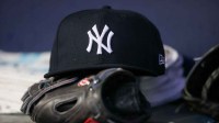 A detailed view of a New York Yankees hat and glove on the bench against the Atlanta Braves in the third inning at Truist Park.
