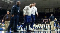 Notre Dame Fighting Irish head coach Micah Shrewsberry is helped off the court while wearing a boot against the Duke Blue Devils after the game at Purcell Pavilion at the Joyce Center.