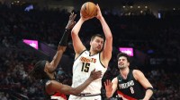 Denver Nuggets center Nikola Jokic (15) grabs a rebound over Portland Trail Blazers guard Jrue Holiday (5) and forward Deni Avdija (8) during first half at Moda Center.