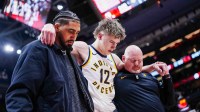 Pacers guard Johnny Furphy (12) leaves the game after injuring himself during the second half against the Toronto Raptors at Scotiabank Arena with an ACL injury in the background