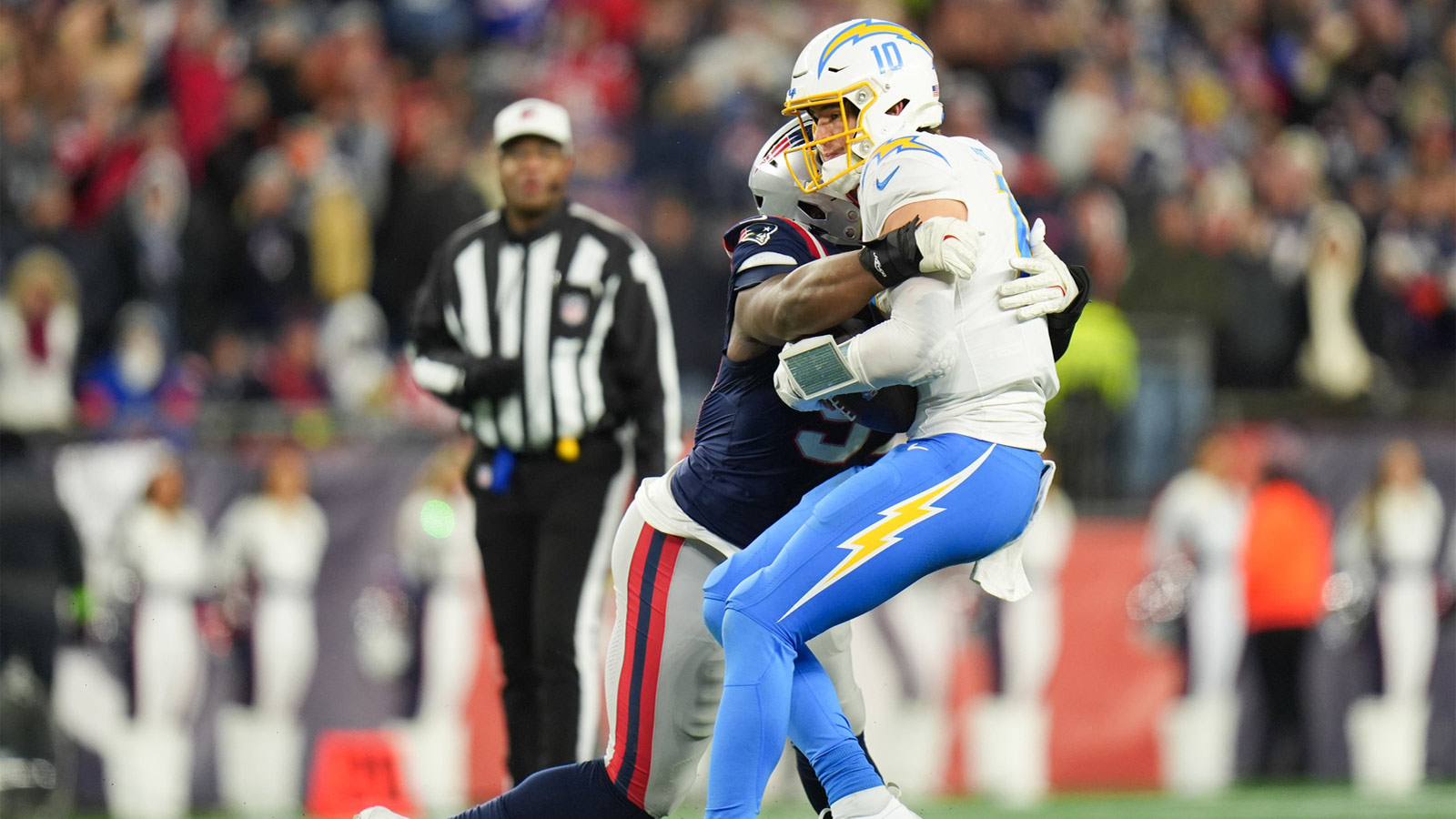 New England Patriots defensive end Milton Williams (97) sacks Los Angeles Chargers quarterback Justin Herbert (10) during the fourth quarter in an AFC Wild Card Round game at Gillette Stadium