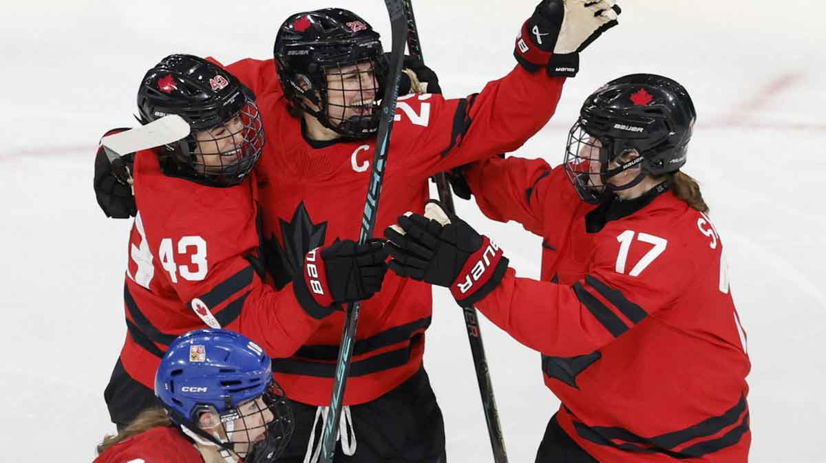 Kristin O'Neill of Canada celebrates scoring their first goal with Marie-Philip Poulin of Canada and Ella Shelton of Canada against Czechia in women's ice hockey group B play during the Milano Cortina 2026 Olympic Winter Games at Milano Rho Ice Hockey Arena.