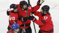 Kristin O'Neill of Canada celebrates scoring their first goal with Marie-Philip Poulin of Canada and Ella Shelton of Canada against Czechia in women's ice hockey group B play during the Milano Cortina 2026 Olympic Winter Games at Milano Rho Ice Hockey Arena.