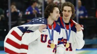 Quinn Hughes (43) of the United States and Jack Hughes (86) of the United States celebrate after defeating Canada in the men's ice hockey gold medal game during the Milano Cortina 2026 Olympic Winter Games at Milano Santagiulia Ice Hockey Arena.