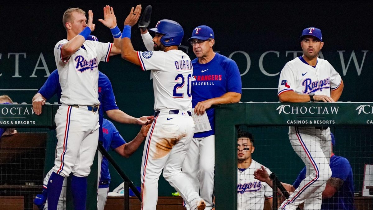 Texas Rangers shortstop Ezequiel Duran (20) is greeted at the dugout by third baseman Josh Jung (6) after scoring during the third inning against the Miami Marlins at Globe Life Field.