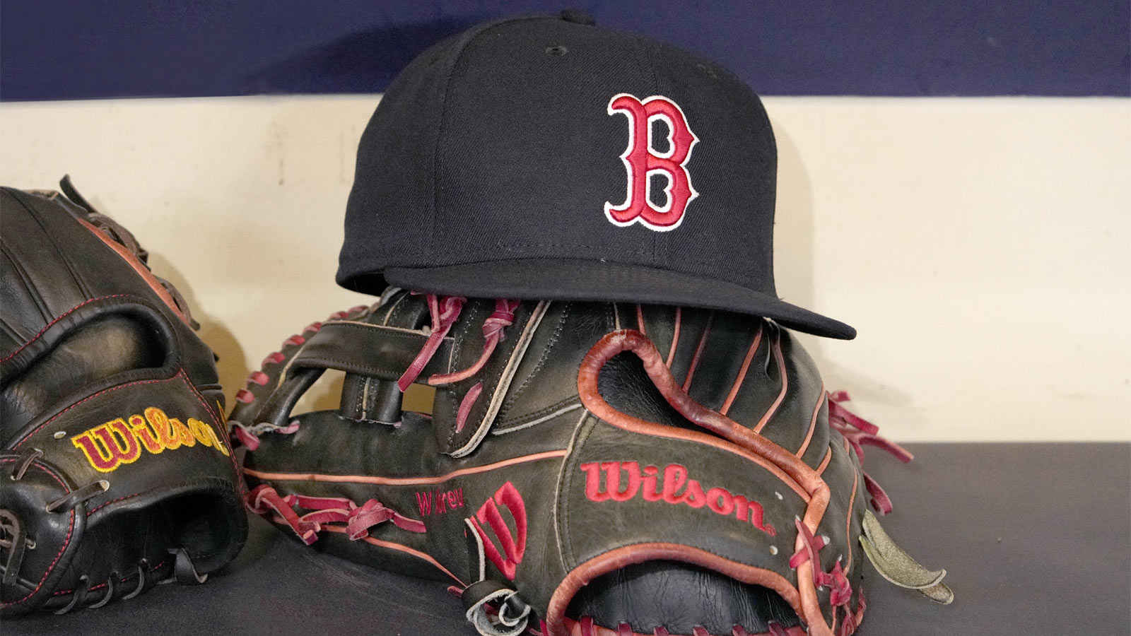 A Boston Red Sox hat and glove sit in the dug out before a game against the Milwaukee Brewers at American Family Field.