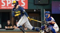 Milwaukee Brewers first baseman Rhys Hoskins (12) follows through on his RBI single against the Texas Rangers during the sixth inning at Globe Life Field.