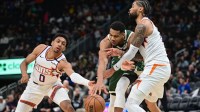 Milwaukee Bucks forward Giannis Antetokounmpo (34) drives for the basket between Phoenix Suns guard Ryan Dunn (0) and center Nick Richards (2) in the third quarter at Fiserv Forum.
