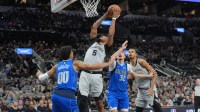 San Antonio Spurs guard Stephon Castle (5) goes up for a shot between Dallas Mavericks guard Max Christie (00) and forward Cooper Flagg (32) in the first half at Frost Bank Center.