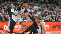 San Antonio Spurs guard Stephon Castle (5) helps up forward Victor Wembanyama (1) in the first half against the Dallas Mavericks at Frost Bank Center.