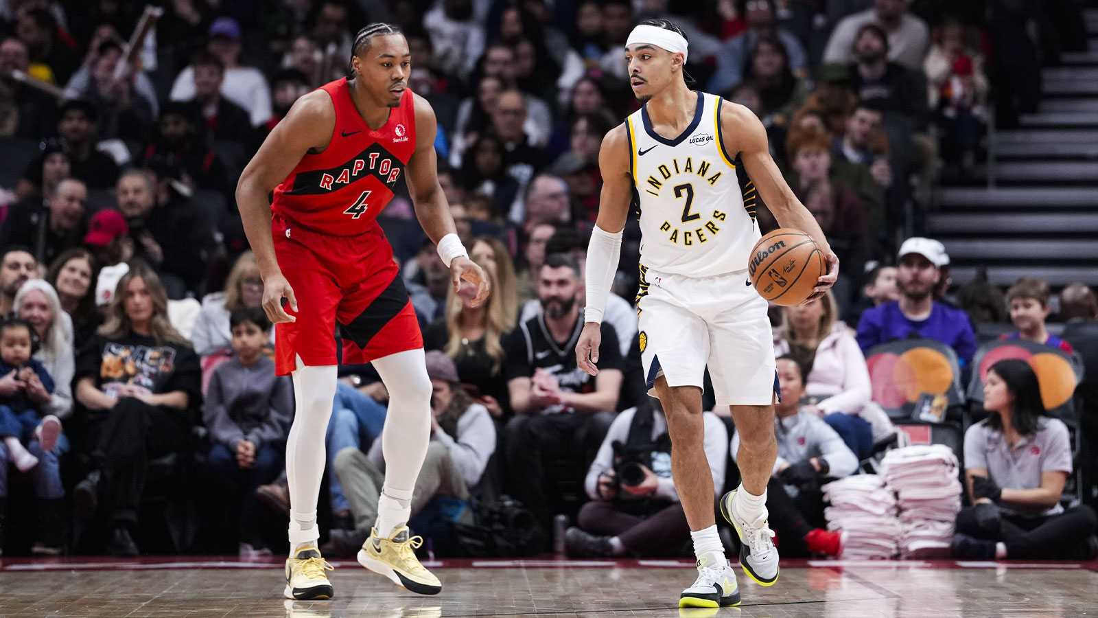 Indiana Pacers guard Andrew Nembhard (2) dribbles against Toronto Raptors forward Scottie Barnes (4) during the first half at Scotiabank Arena.