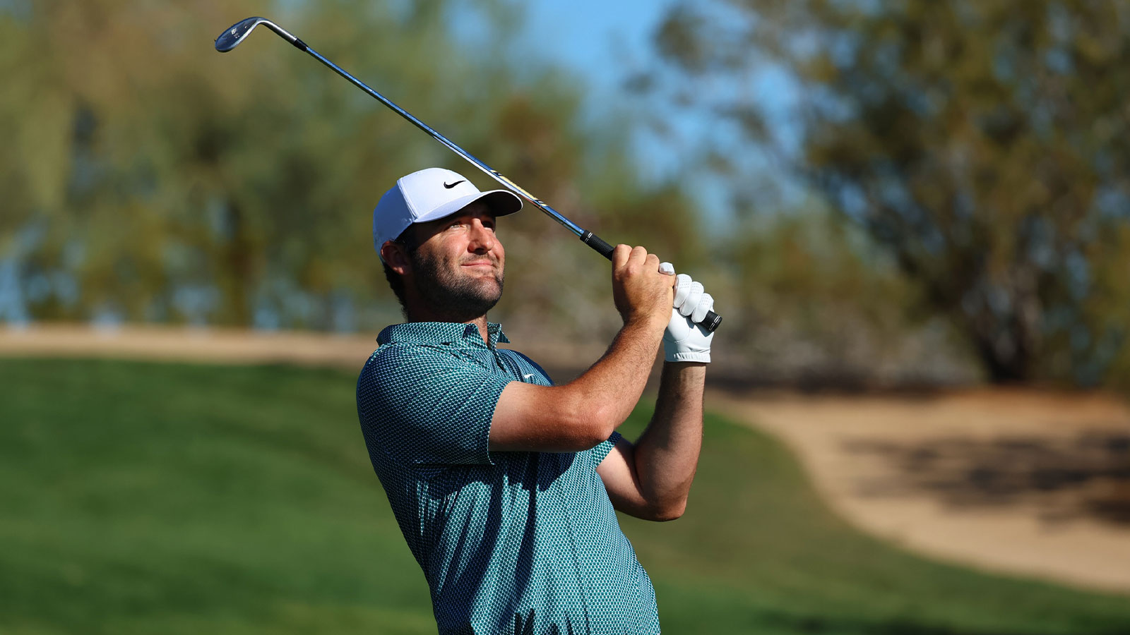 Scottie Scheffler of the United States smiles after hitting a shot on the fairway of hole 2 during the final round of the WM Phoenix Open golf tournament. 
