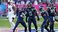 Seattle Seahawks defensive end DeMarcus Lawrence (0) and Seattle Seahawks cornerback Devon Witherspoon (21) react after a play during the first quarter against the New England Patriots in Super Bowl LX at Levi's Stadium.