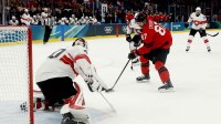 Sidney Crosby of Canada in action with Akira Schmid of Switzerland in men's ice hockey group A play during the Milano Cortina 2026 Olympic Winter Games at Milano Santagiulia Ice Hockey Arena.