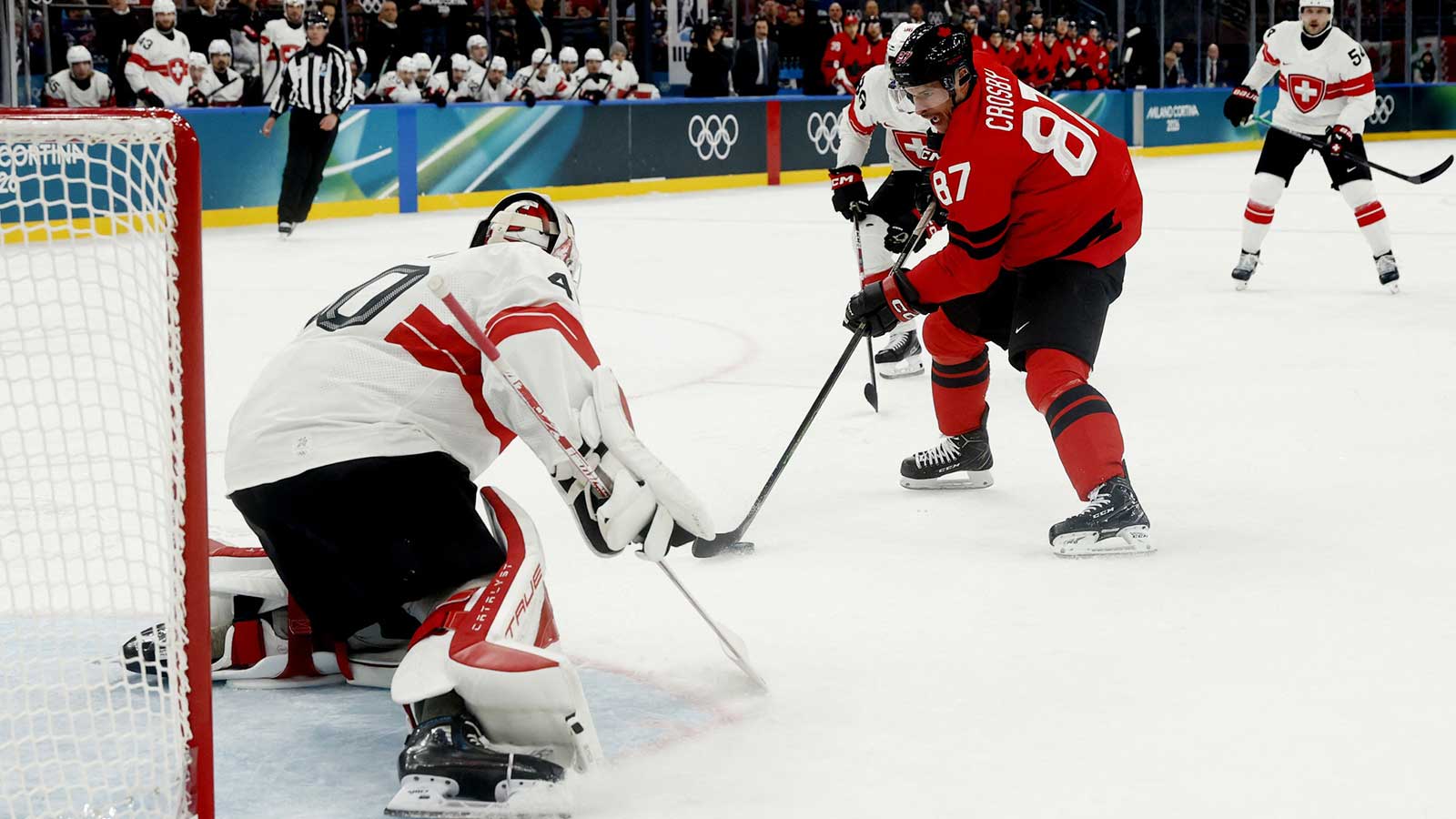 Sidney Crosby of Canada in action with Akira Schmid of Switzerland in men's ice hockey group A play during the Milano Cortina 2026 Olympic Winter Games at Milano Santagiulia Ice Hockey Arena.