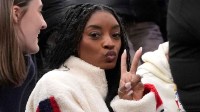 United States gymnast Simone Biles is pictured in the stands in a men's ice hockey quarterfinal between the United States and Sweden during the Milano Cortina 2026 Olympic Winter Games at Milano Santagiulia Ice Hockey Arena.