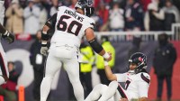 Houston Texans center Jake Andrews (60) helps up quarterback C.J. Stroud (7) in the second quarter against the New England Patriots in an AFC Divisional Round game at Gillette Stadium.