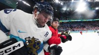 Sam Bennett (9) of Canada checks Mikko Rantanen (96) of Finland into the boards during the second period in a men's ice hockey semifinal during the Milano Cortina 2026 Olympic Winter Games at Milano Santagiulia Ice Hockey Arena