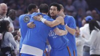 Thunder guard Jared McCain (3) hugs a teammate before the start of a game against the Milwaukee Bucks at Paycom Center