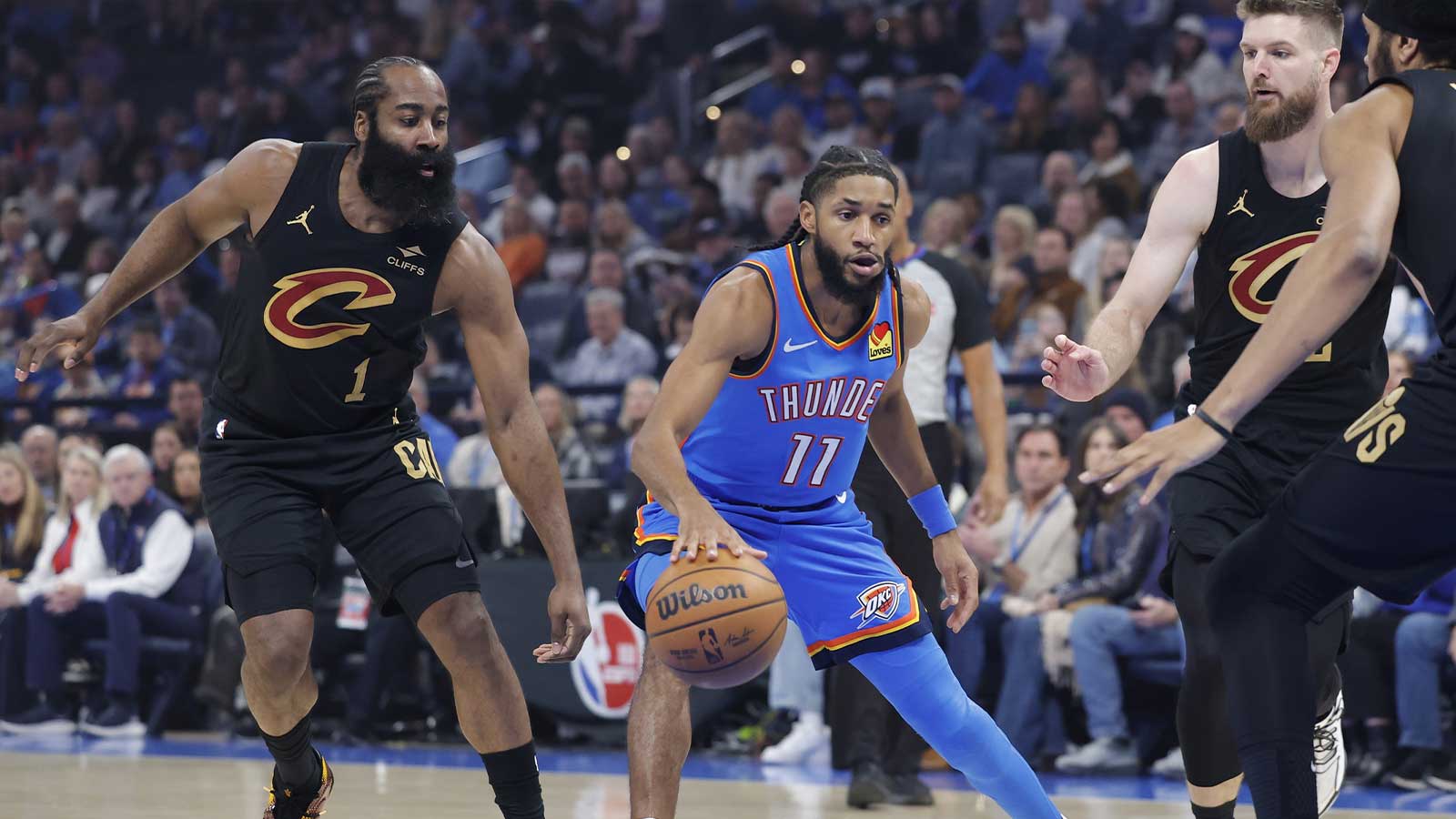 Thunder guard Isaiah Joe (11) drives between Cleveland Cavaliers guard James Harden (1) and Cleveland Cavaliers forward Dean Wade (32) during the first half at Paycom Center