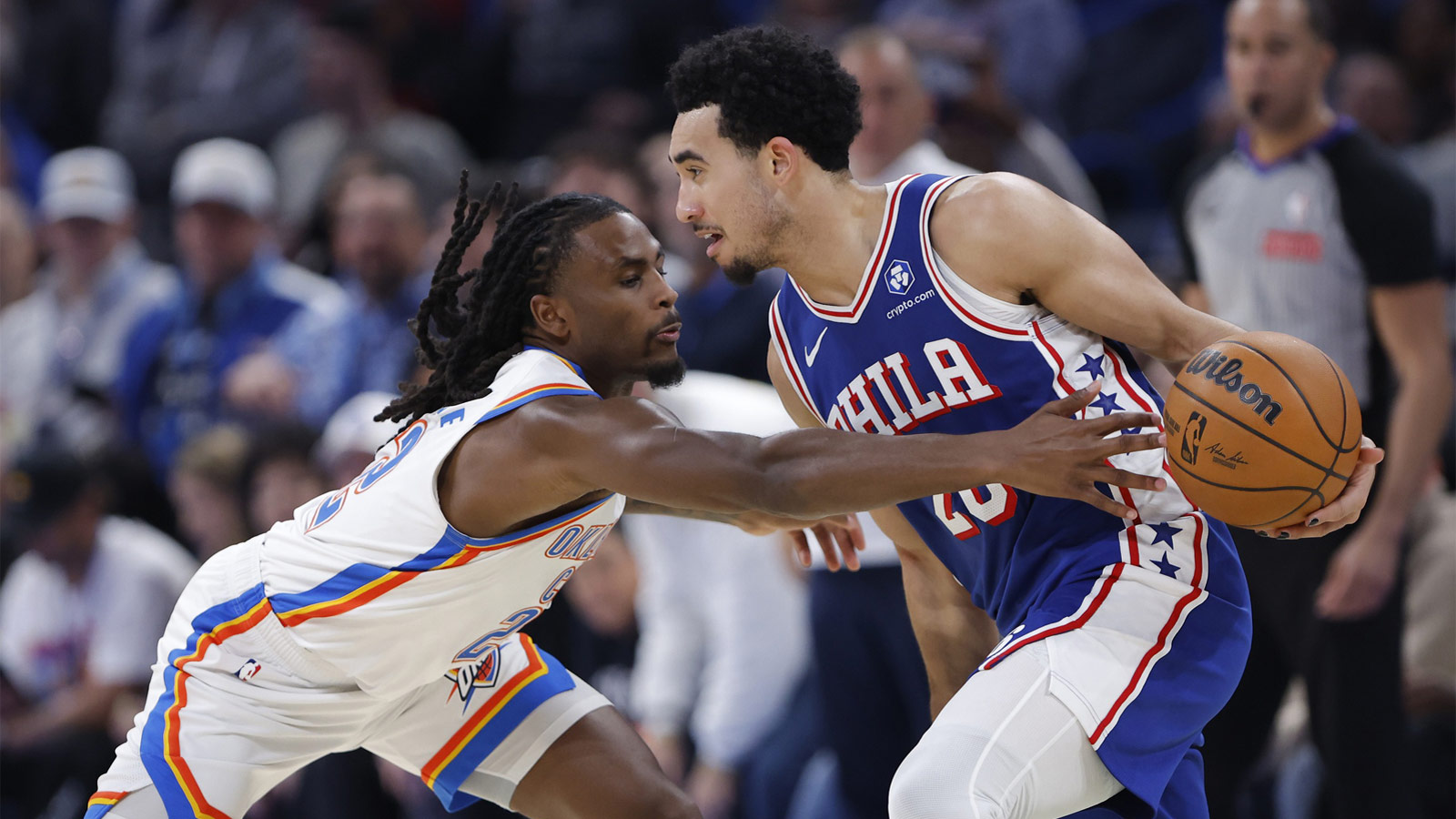 Thunder guard Cason Wallace (22) reaches to steal the ball away from Philadelphia 76ers guard Jared McCain (20) during the second half at Paycom Center