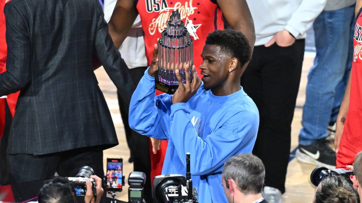 Timberwolves' Anthony Edwards (5) of the Minnesota Timberwolves celebrates with the MVP trophy after the championship game during the 75th NBA All Star Game at Intuit Dome with ESPN's Stephen A Smith in the background