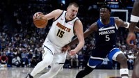 Timberwolves' Anthony Edwards (5) defends Nuggets' Nikola Jokic