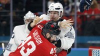 Tom Wilson of Canada clashes with Pierre Crinon of France in men's ice hockey group A play during the Milano Cortina 2026 Olympic Winter Games at Milano Santagiulia Ice Hockey Arena.