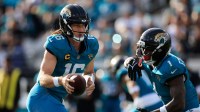 Jacksonville Jaguars quarterback Trevor Lawrence (16) fakes the hands off to running back Travis Etienne Jr. (1) during the fourth quarter of an NFL football AFC Wild Card playoff matchup, Sunday, Jan. 11, 2026, in Jacksonville, Fla. The Bills defeated the Jaguars 27-24.
