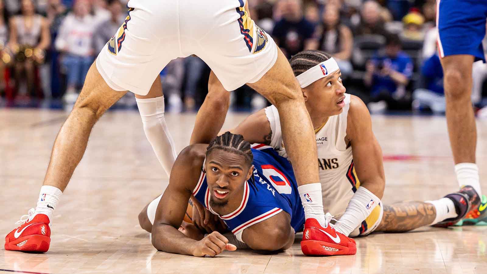Philadelphia 76ers guard Tyrese Maxey (0) and New Orleans Pelicans guard Jeremiah Fears (0) fight for possession during the second half at Smoothie King Center.