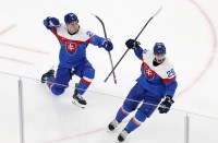 Juraj Slafkovsky of Slovakia celebrates scoring their first goal with Michal Ivan of Slovakia against Finland in men's ice hockey group B play during the Milano Cortina 2026 Olympic Winter Games at Milano Santagiulia Ice Hockey Arena.
